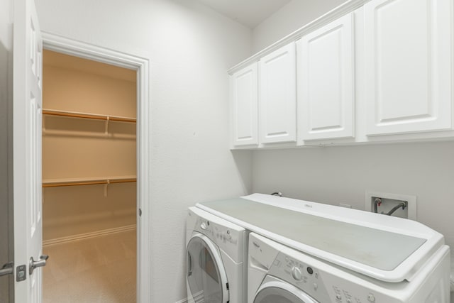 clothes washing area featuring separate washer and dryer, cabinets, and carpet flooring