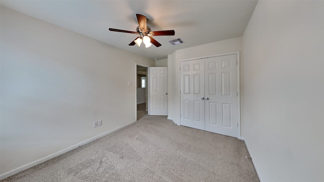 unfurnished bedroom with light carpet, a closet, and ceiling fan