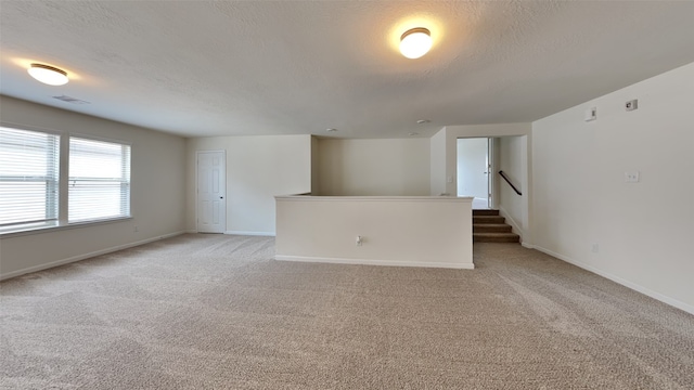 carpeted empty room with a textured ceiling