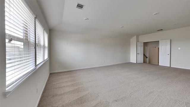 carpeted spare room with lofted ceiling