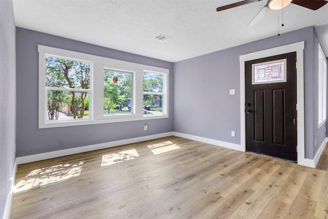 foyer featuring light hardwood / wood-style floors, ceiling fan, and a textured ceiling