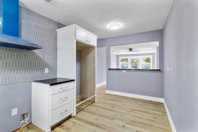 kitchen featuring white cabinetry, ceiling fan, a textured ceiling, and light hardwood / wood-style flooring