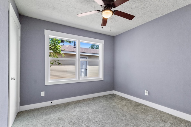 carpeted empty room with ceiling fan and a textured ceiling