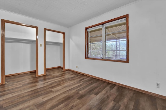 unfurnished bedroom featuring ornamental molding and dark hardwood / wood-style floors