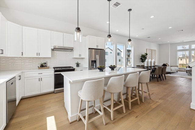 kitchen featuring a kitchen island, stainless steel appliances, and a wealth of natural light