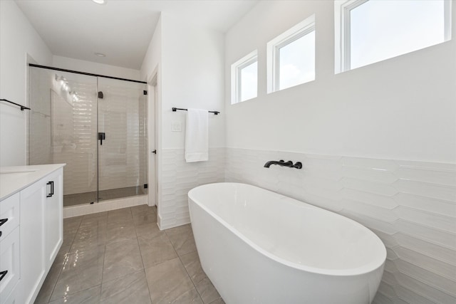 bathroom featuring tile walls, tile patterned floors, vanity, and separate shower and tub