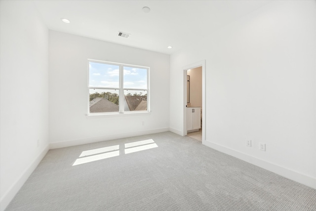 unfurnished room featuring light colored carpet