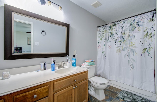 full bathroom featuring a textured ceiling, shower / tub combo with curtain, vanity, and toilet