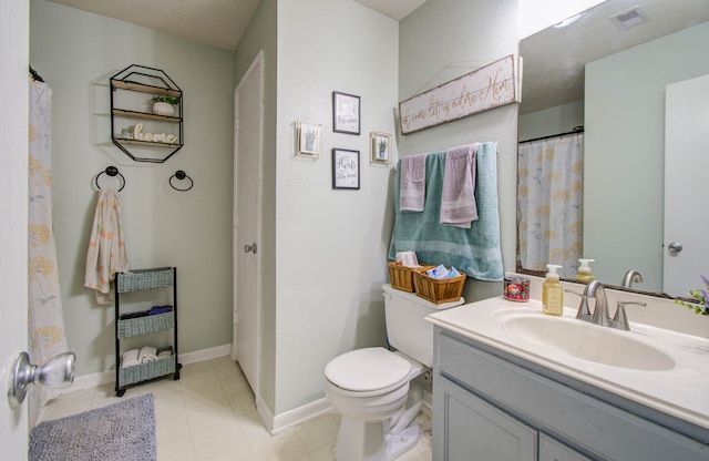 bathroom with a textured ceiling, tile patterned flooring, vanity, and toilet