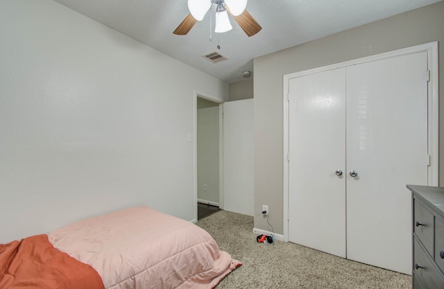 carpeted bedroom with ceiling fan and a closet