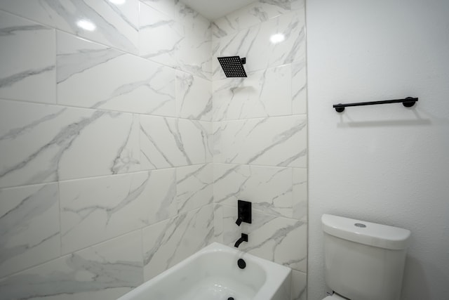 bathroom with a skylight, tiled shower / bath, and toilet