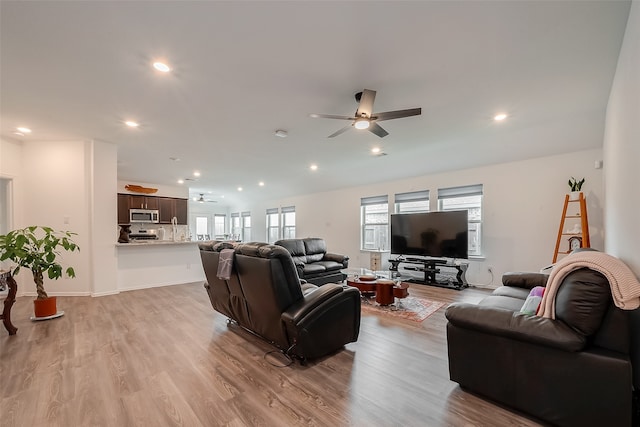 living room with ceiling fan and light hardwood / wood-style floors