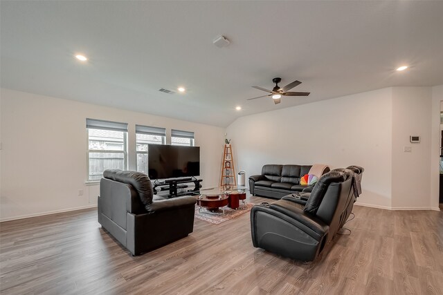 living room featuring ceiling fan, vaulted ceiling, and light hardwood / wood-style floors