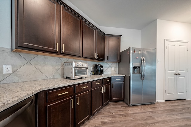 kitchen with decorative backsplash, dark brown cabinetry, light hardwood / wood-style flooring, stainless steel appliances, and light stone countertops