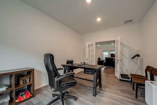 office space with hardwood / wood-style floors, vaulted ceiling, and french doors