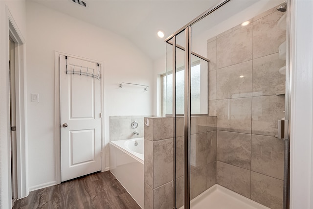 bathroom featuring lofted ceiling, plus walk in shower, and hardwood / wood-style flooring