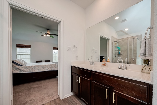 bathroom with ceiling fan, vanity, a shower with shower door, hardwood / wood-style flooring, and vaulted ceiling