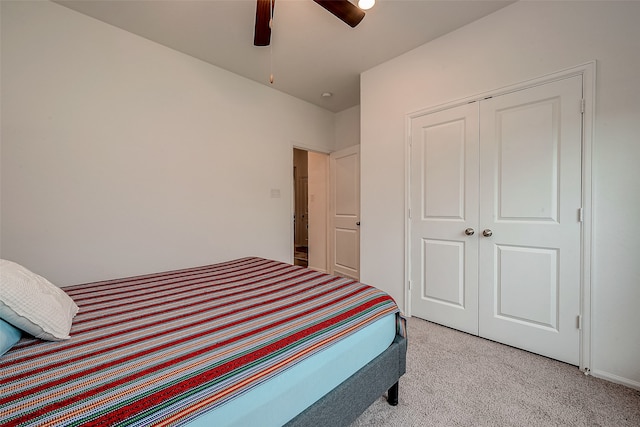 carpeted bedroom with ceiling fan and a closet