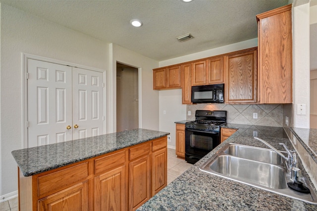 kitchen featuring light tile patterned flooring, backsplash, a textured ceiling, black appliances, and sink