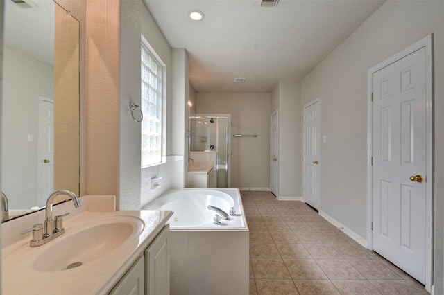 bathroom with a healthy amount of sunlight, tile patterned flooring, vanity, and shower with separate bathtub