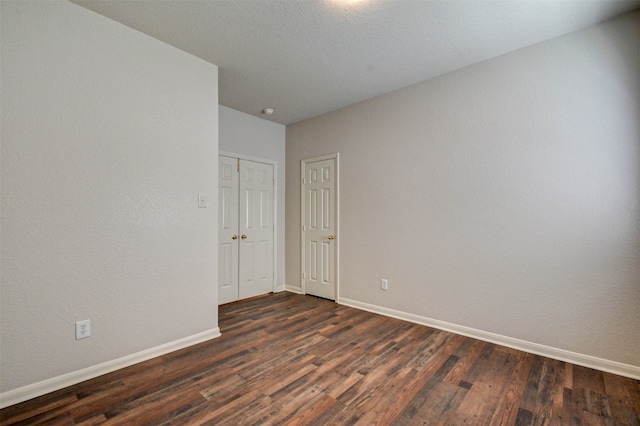 unfurnished room featuring dark wood-type flooring