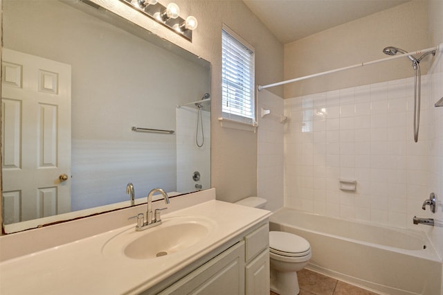 full bathroom featuring tile patterned flooring, tiled shower / bath, vanity, and toilet