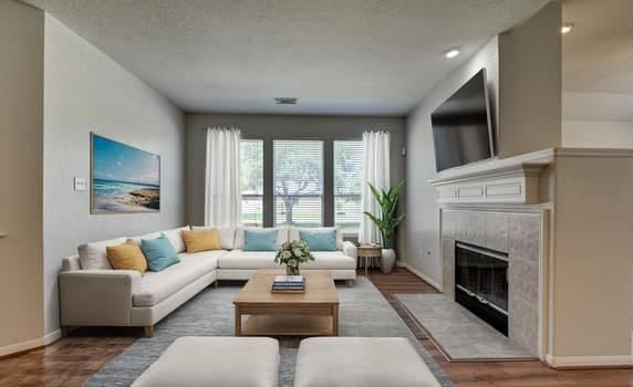 living room featuring wood-type flooring, a textured ceiling, and a tile fireplace