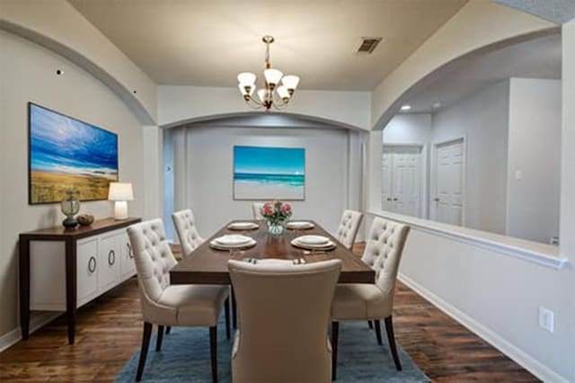 dining space with a chandelier and dark hardwood / wood-style flooring