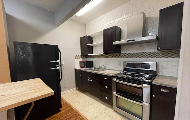 kitchen featuring backsplash, wall chimney exhaust hood, light wood-type flooring, black appliances, and sink