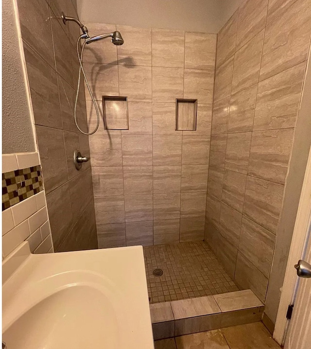 bathroom with tile walls, tile patterned floors, and tiled shower