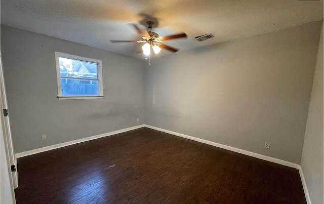 empty room featuring a textured ceiling, dark hardwood / wood-style floors, and ceiling fan