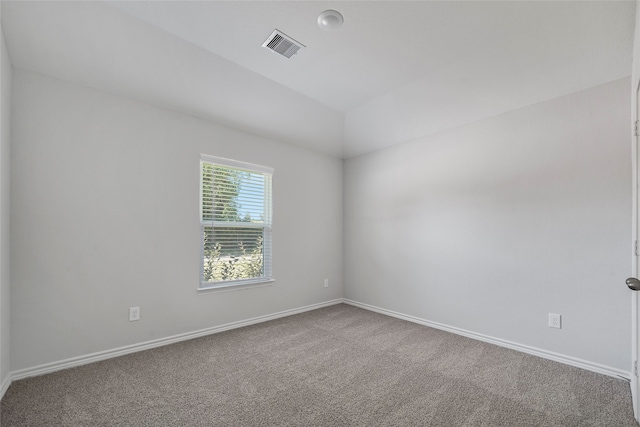 carpeted empty room with lofted ceiling