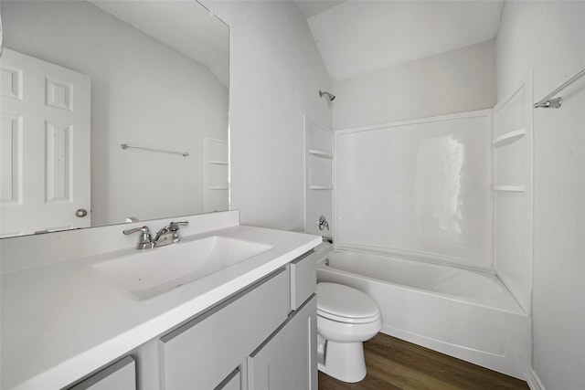 full bathroom with wood-type flooring, vaulted ceiling, bathing tub / shower combination, vanity, and toilet