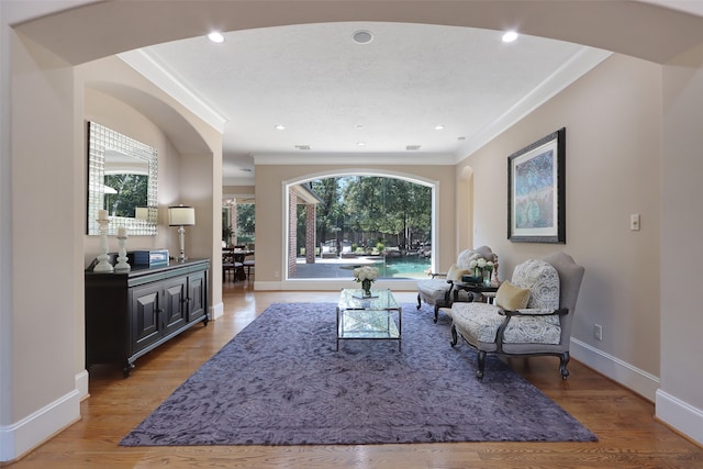 living room with a wealth of natural light, ornamental molding, and hardwood / wood-style flooring