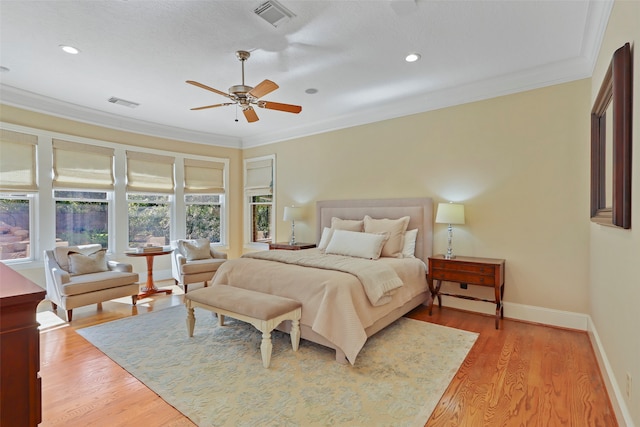 bedroom featuring ornamental molding, light hardwood / wood-style floors, and ceiling fan