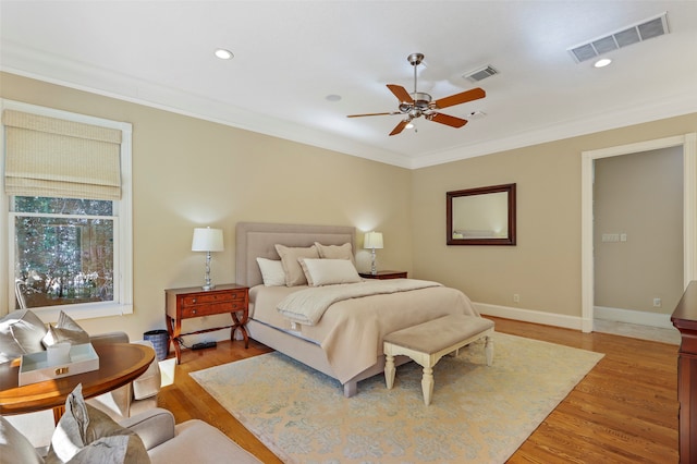 bedroom with ornamental molding, hardwood / wood-style floors, and ceiling fan