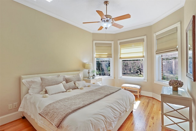 bedroom featuring crown molding, light wood-type flooring, and ceiling fan