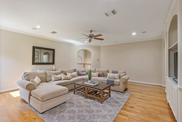 living room featuring light hardwood / wood-style floors, ornamental molding, and ceiling fan