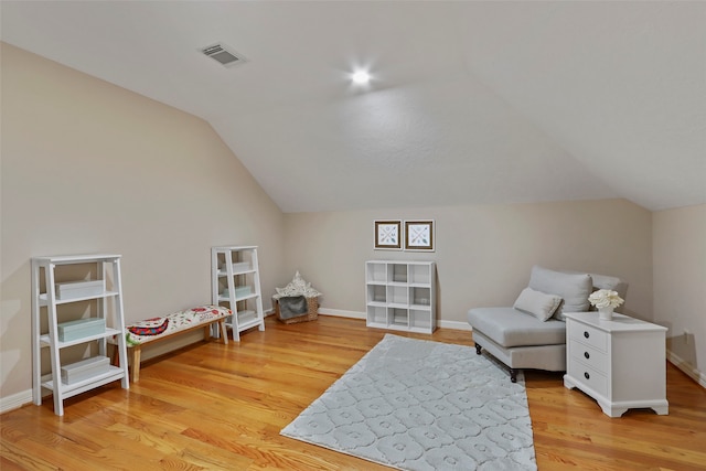 living area with light hardwood / wood-style floors and vaulted ceiling