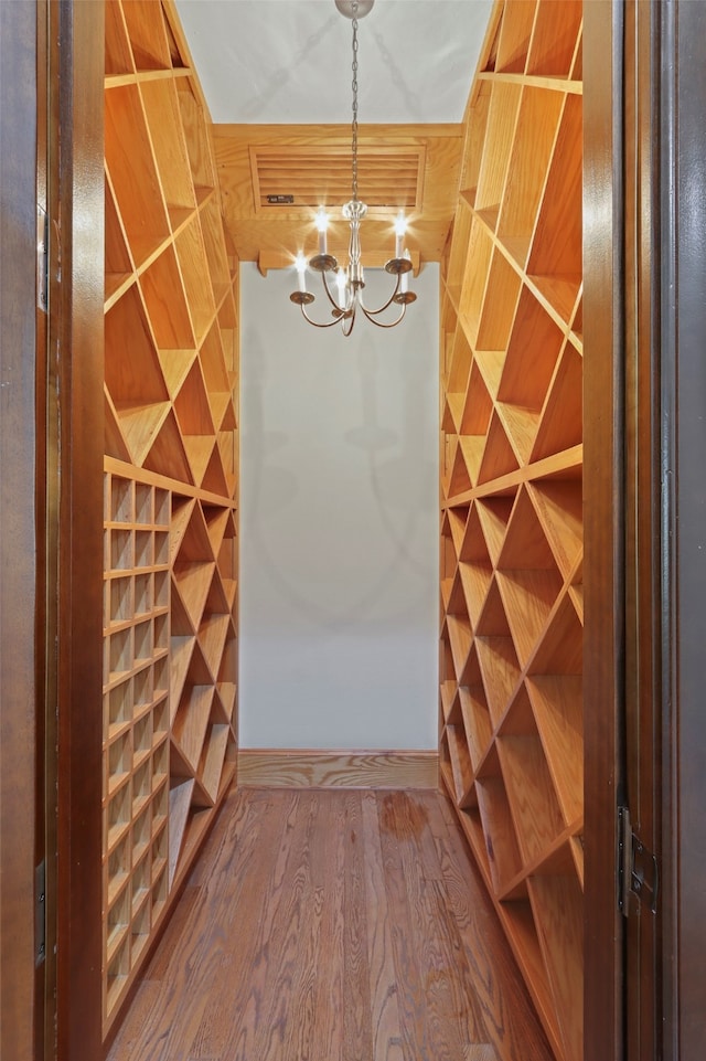 wine cellar featuring a notable chandelier and hardwood / wood-style flooring