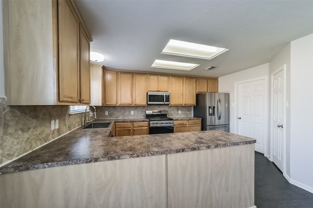 kitchen with light brown cabinetry, stainless steel appliances, sink, and kitchen peninsula