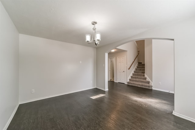 unfurnished room featuring dark hardwood / wood-style floors and a notable chandelier