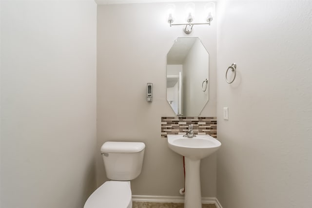 bathroom with sink, toilet, and decorative backsplash