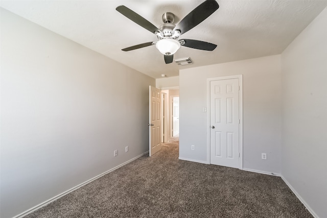 unfurnished bedroom featuring dark carpet and ceiling fan