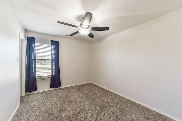 carpeted spare room featuring a textured ceiling and ceiling fan