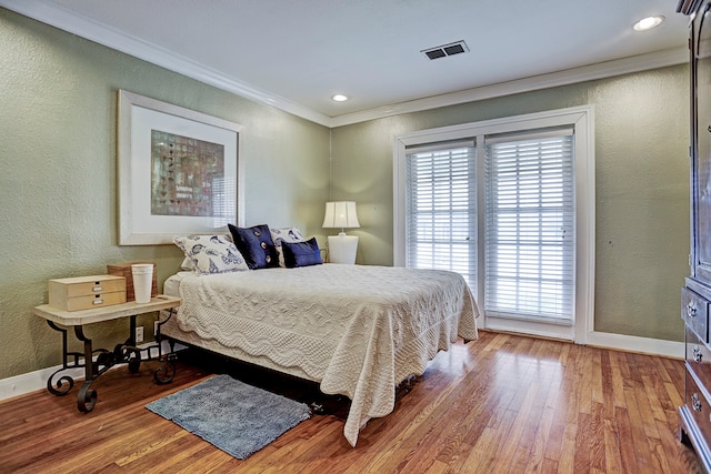 bedroom with ornamental molding and hardwood / wood-style flooring