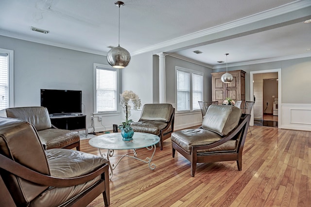 living room with light wood-type flooring, a healthy amount of sunlight, and crown molding