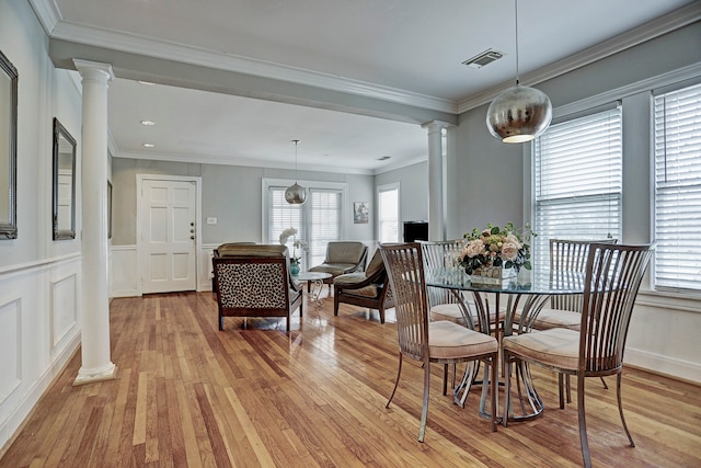 dining room featuring ornamental molding, light wood-type flooring, and plenty of natural light