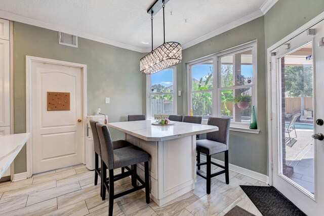 dining area featuring a textured ceiling, rail lighting, and ornamental molding