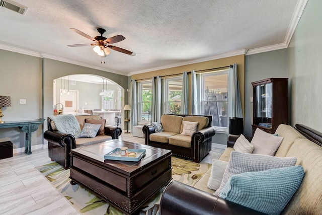 living room with a textured ceiling, ceiling fan with notable chandelier, and crown molding